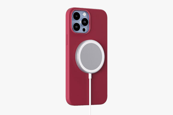 iPhone in einer roten Hülle, an dem ein Induktivladegerät befestigt ist