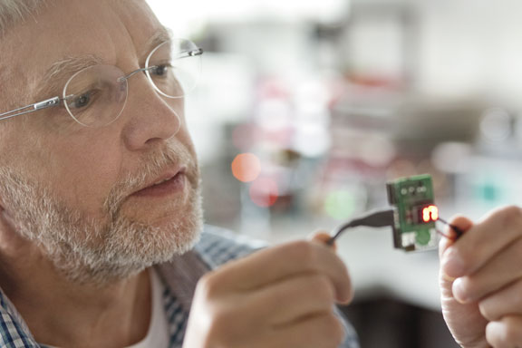 Mann prüft eine elektronische Leiterplatte