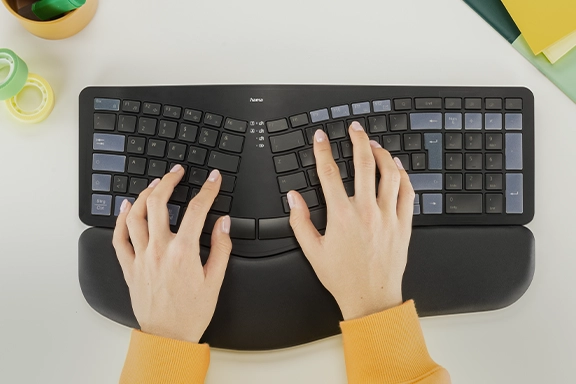 Bird's eye view of hands typing on the Hama ‘WK-900 Ergo’ multi-device keyboard