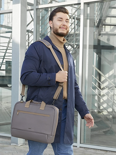 Businessman carries the Hama "Ultra Lightweight" laptop bag over his shoulder on the way to the next meeting